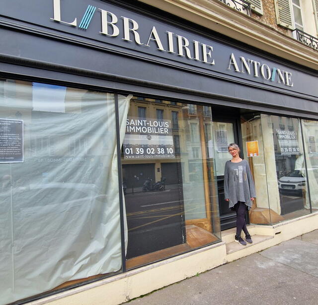 La nouvelle gérante Ingrid Delaetre devant la devanture de l'ancienne librarire Antoine qui deviendra Mon Chat Pitre en avril prochain