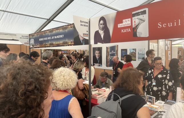 Sous le chapiteau, les lecteurs se pressent devant les stands de l'Olivier et du Seuil, où Jay McInerney dédicace Rendez-vous sur l'autre rive