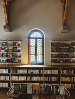 La librairie La Maison des Feuilles a pris place sous les vitraux de la Chapelle de la Gare.